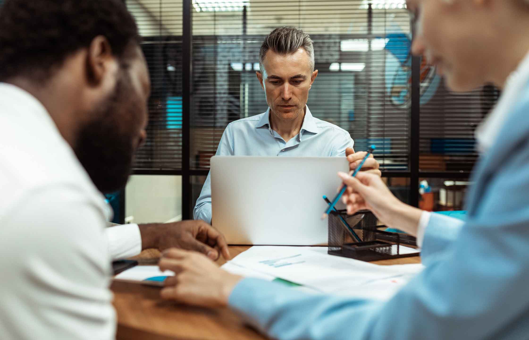 Engineering leader and team members reviewing software development strategy and cost optimization metrics during collaboration meeting in modern office.