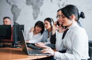 Integrated software development team working together with headsets and laptops, demonstrating seamless collaboration and professional team augmentation in action.