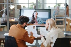 Engineering leaders reviewing candidate resumes during remote video interview with nearshore candidate, evaluating cultural fit and collaboration potential for team integration.