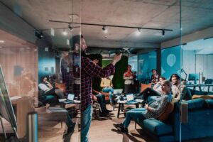 Engineering team leader presenting data-driven strategy during collaborative brainstorming session in modern office, demonstrating smart company culture and inclusive leadership