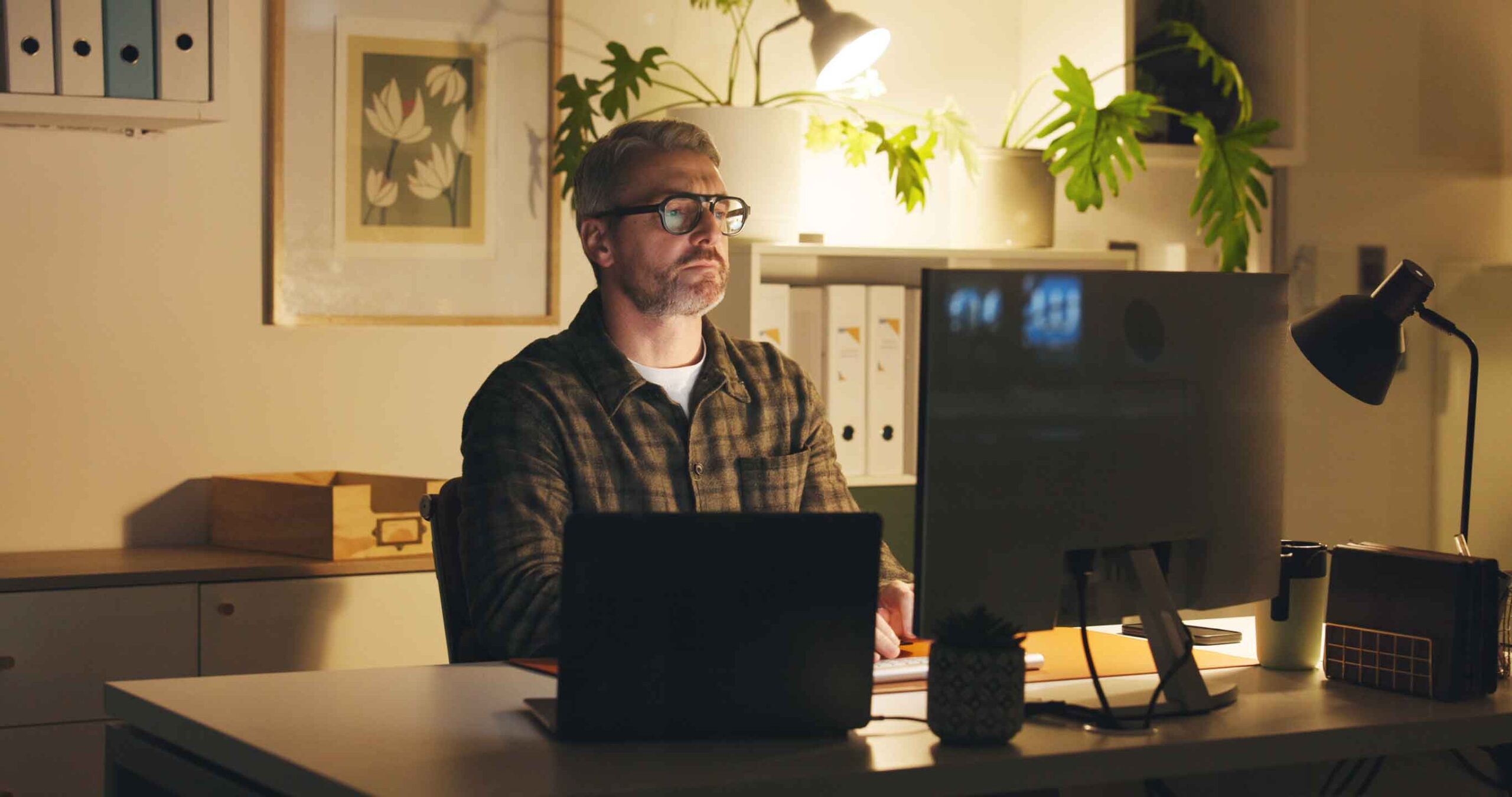 Software engineer focused on development work at home office setup, representing remote productivity and concentrated problem-solving in software delivery